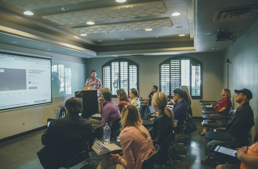 Adult learners in a training room watching a presentation